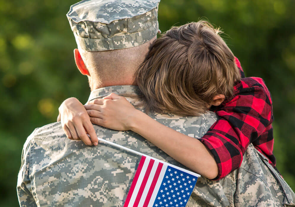 boy hugging a solider